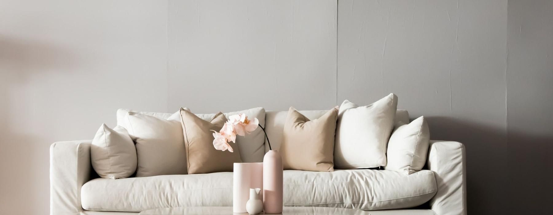 living room with a large couch and vases on a coffee table